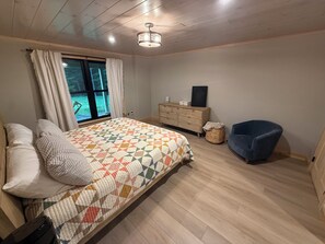 Ein Schlafzimmer mit einem Bett, einem Schminktisch, einem Stuhl und einem Fenster.