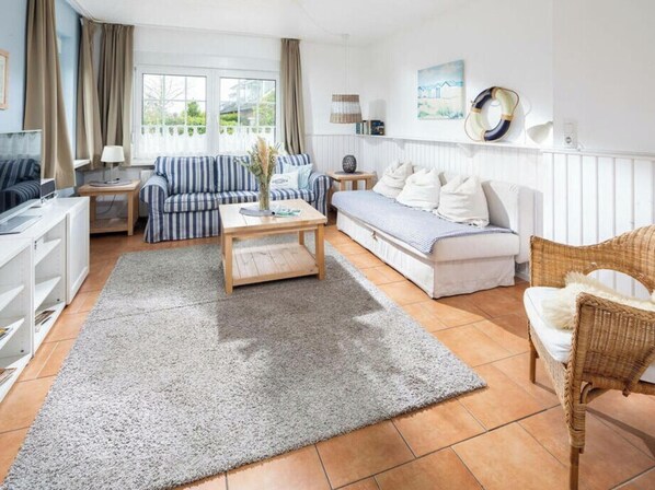 A modern living room with a sofa, a coffee table, and a television. - Mariechen am Meer Apt. 1 - Norddeich (Norden)