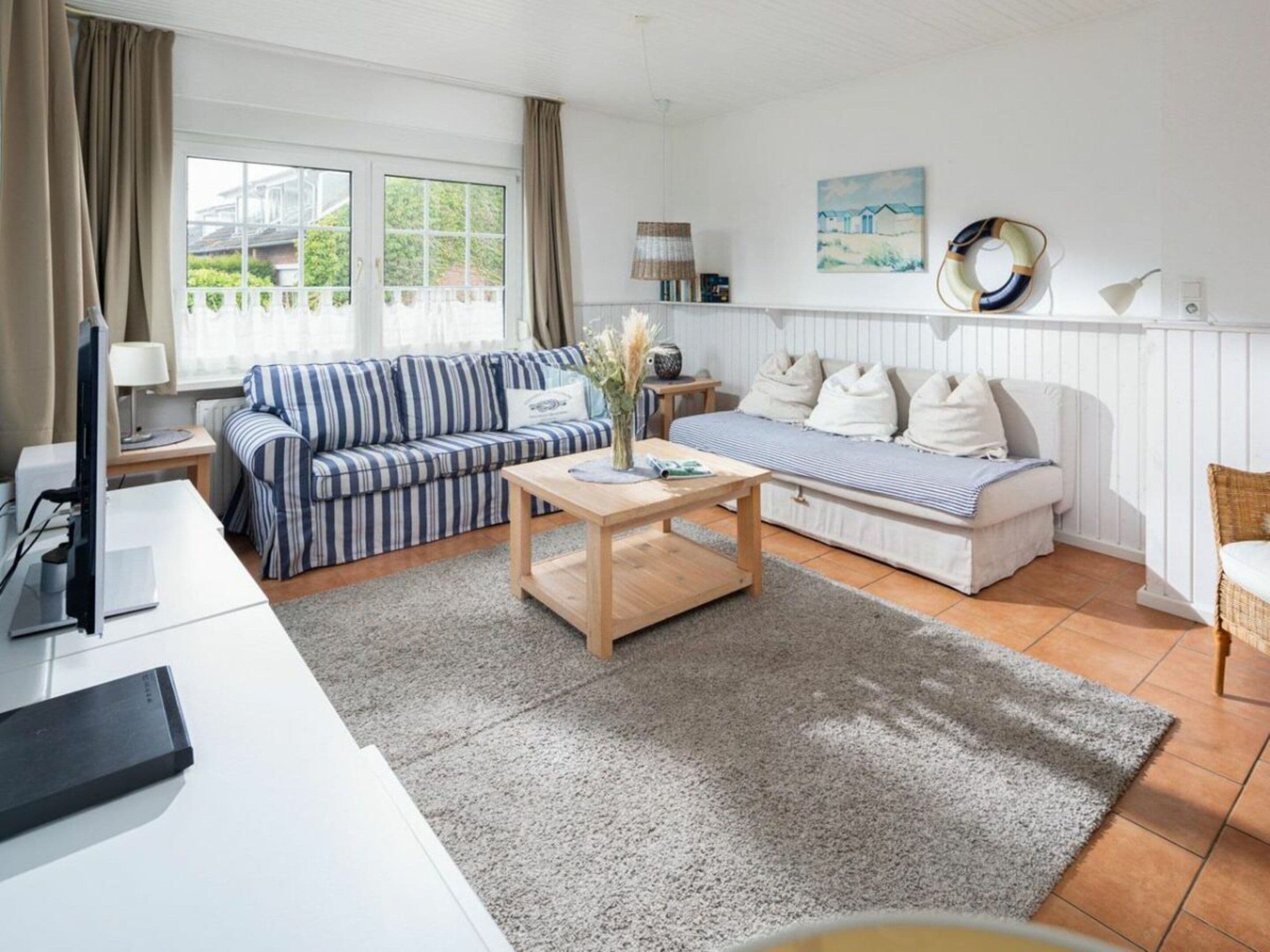 A living room with a striped sofa, a wooden coffee table, and a white couch.