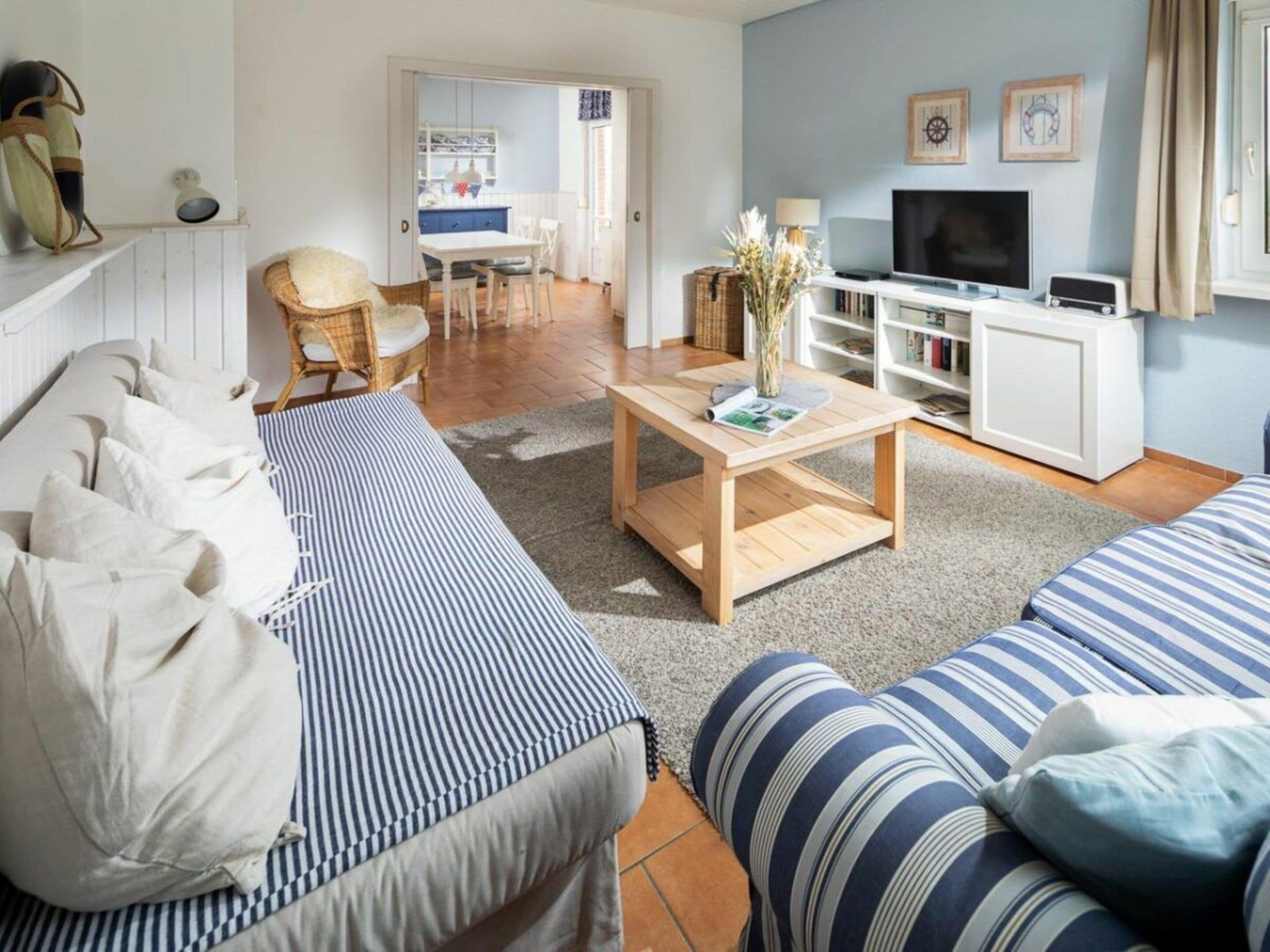 A living room with a sofa, a coffee table, and a television.