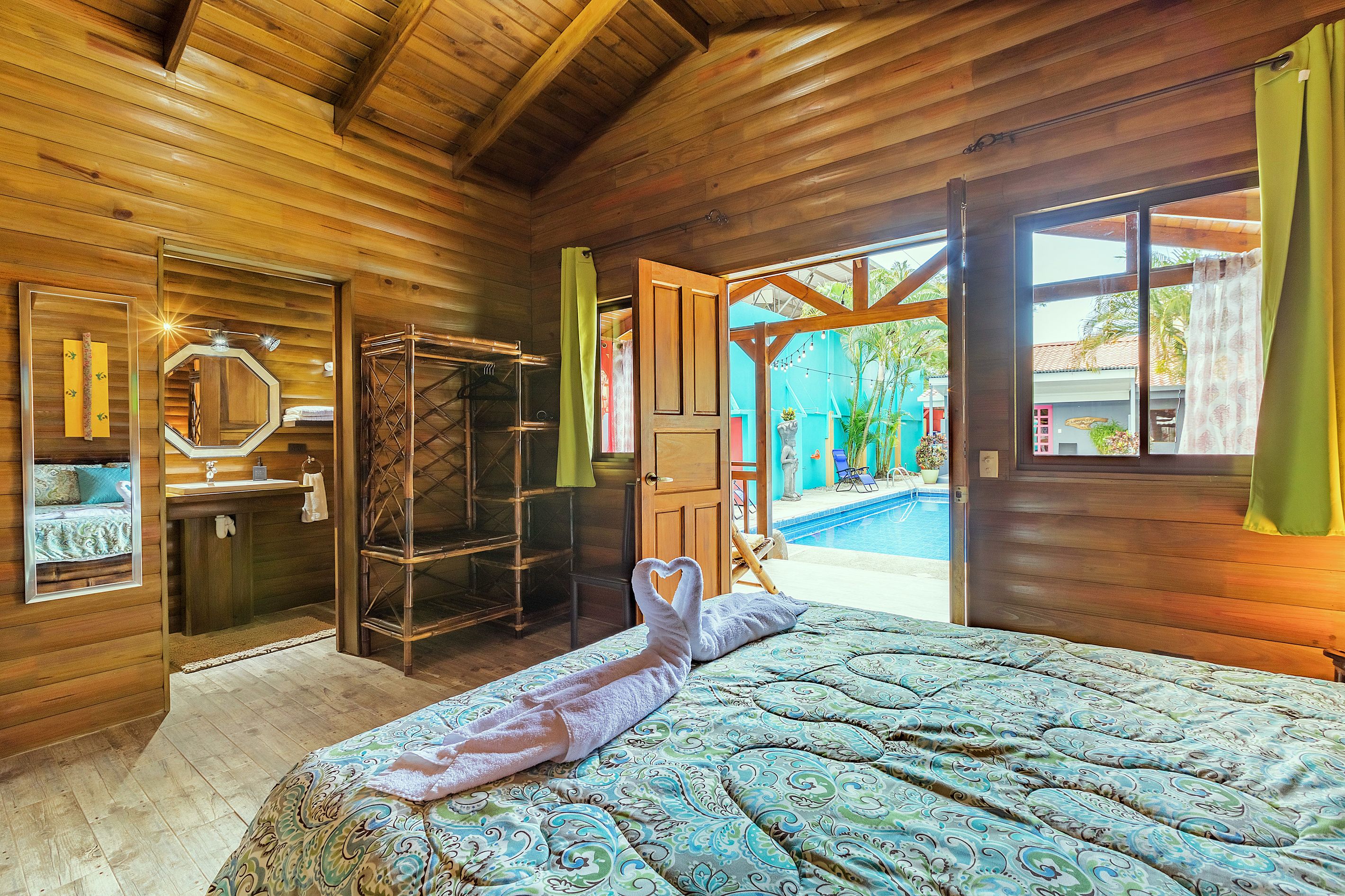 Une pièce en bois avec un lit, une salle de bain et une vue sur une piscine.