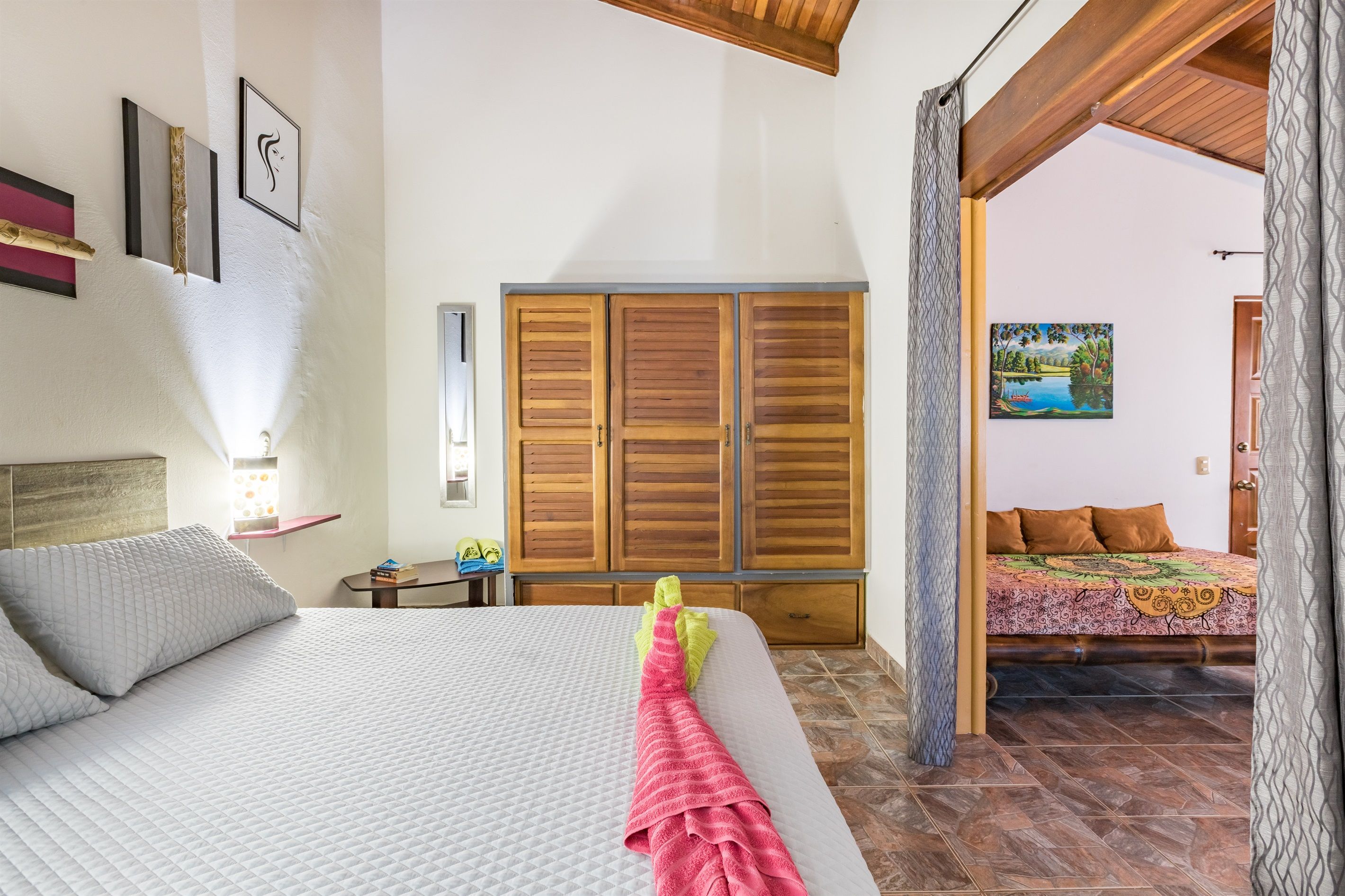 Un dormitorio con una cama grande, un armario de madera y un cuadro en la pared.
