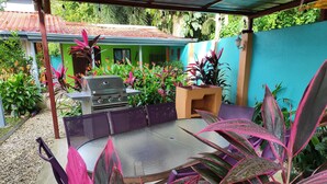 An outdoor patio with a grill, seating area, and potted plants. - Tropical Paradise w/ 2 Sapacious Cabinas AC & Pool (Playa Herradura)