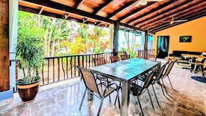 An outdoor dining area with a wooden ceiling, a table, chairs, and potted plants. - Stylish & Cozy Private Rooms in Tropical Paradise (Playa Herradura)