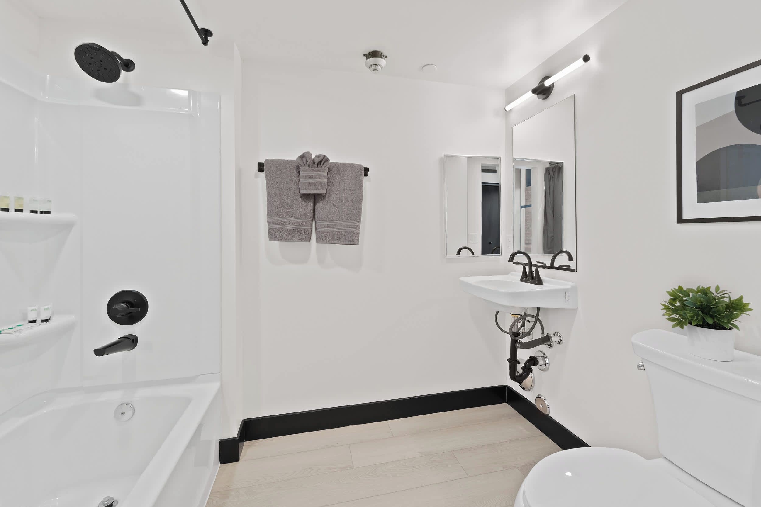 Un baño moderno con bañera, inodoro, lavamanos y ducha.