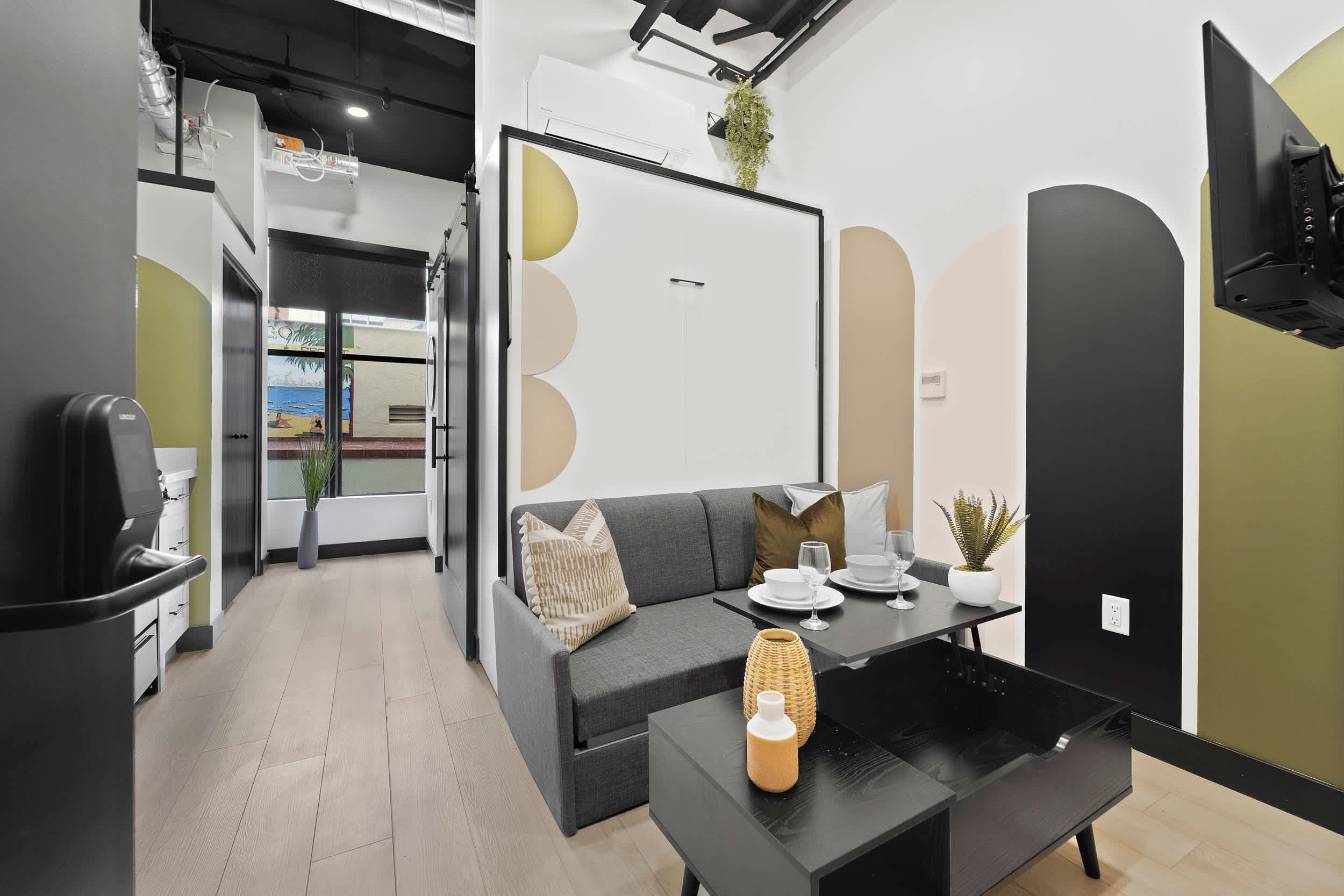 Ein modernes Interieur mit einer Couch, einem Esstisch und einer Pflanze.