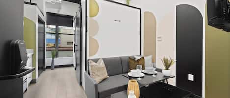 Ein modernes Interieur mit einer Couch, einem Esstisch und einer Pflanze.