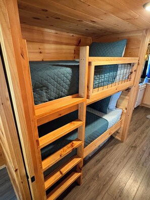 Ein Etagenbett mit Holzrahmen und einer unteren Ablagefläche.