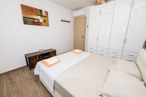A bedroom with a bed, a wardrobe, a desk, and a wall-mounted artwork. - Condo with 2 bdr and parking (Kaštel Stari)