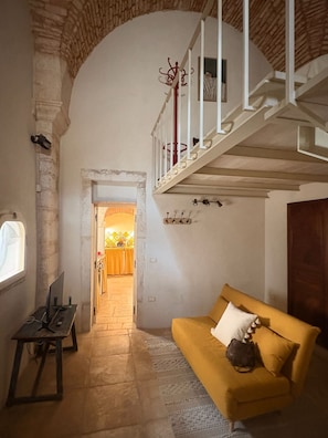 A room with a yellow sofa, a staircase, and a window. - PalazzOliva - Historic Heart of Martina Franca (Martina Franca)