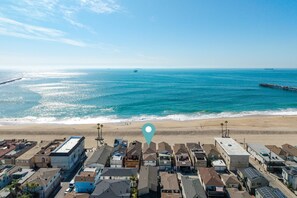 A coastal residential area with houses, a pier, and the ocean. - Beachfront Studio Steps to Main Street (Seal Beach)