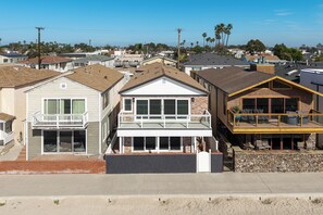 A residential area with houses featuring balconies, large windows, and a mix of brick and siding exteriors. - Beachfront Studio Steps to Main Street (Seal Beach)