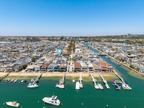 A coastal town with a marina, residential buildings, and a clear blue sky. - Classic Balboa Island Coastal Escape (Newport Beach)