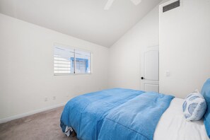 A bedroom with a single bed, a window with blinds, a door, and a ceiling vent. - Coastal Living on Balboa Island (Newport Beach)