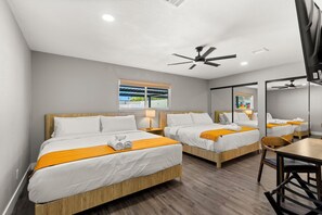 A hotel room with two beds, a ceiling fan, a window with a view, and a mirror. - Pool • Hot tub • Basketball C. • Mini-Golf • Game Room • 26 Guests Max (Las Vegas)