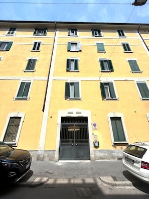 A yellow building with multiple windows and a black door. - Ecletic Jungle - MARTINI'S home (Milano)