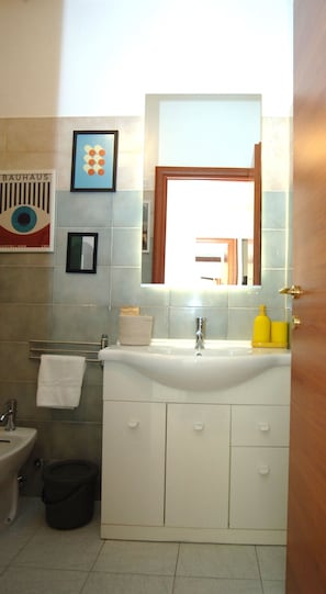 A bathroom with a sink, mirror, and a towel rack. - Ecletic Jungle - MARTINI'S home (Milano)
