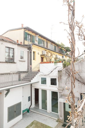 A multi-story building with balconies, a staircase, and a courtyard. - Foresteria MILO MARTINI's Home (Milano)