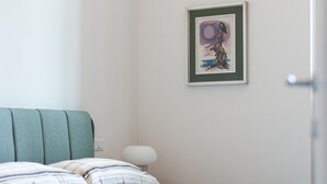 A bedroom with a bed, pillows, a bedside table, and a wall-mounted picture. - Foresteria MILO MARTINI's Home (Milano)