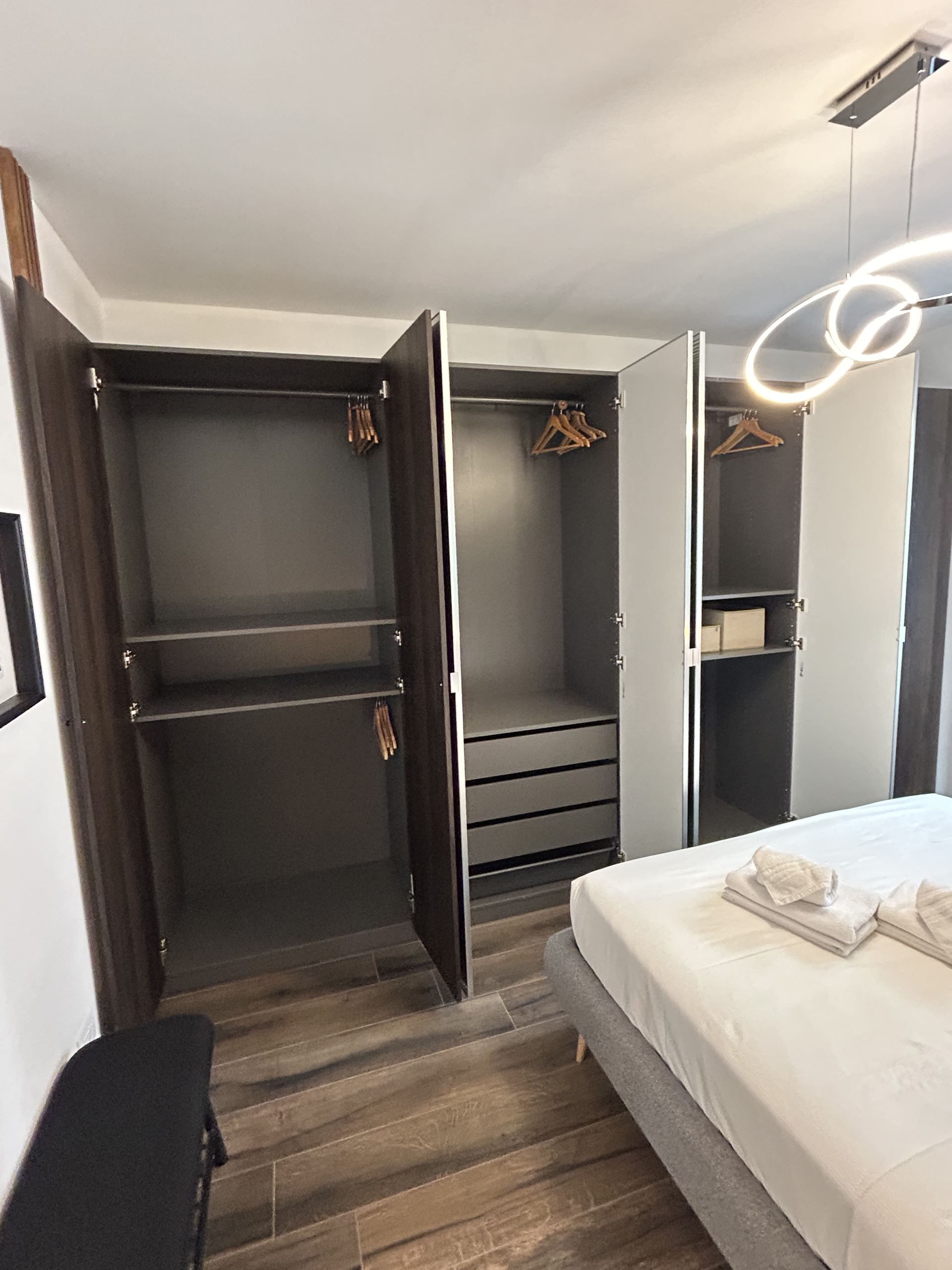 Een slaapkamer met een bed, een kledingkast en een spiegel.