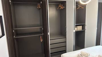 A bedroom with a bed, a wardrobe, and a mirror.