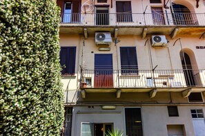 A multi-story building with balconies, air conditioning units, and a tree in the foreground. - Jasmine House - MARTINI's Home, Milano (Milano)
