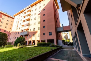 Un edificio residencial de varios pisos con balcones, un patio central y un diseño arquitectónico moderno.