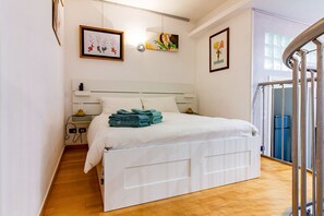A hotel room with a bed, a bedside table, a lamp, and artwork on the walls. - Loft Fashion Design - MARTINI's Home, Milano (Sesto San Giovanni)