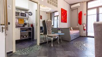 Une chambre d’hôtel moderne dotée d’une kitchenette, d’un coin repas, d’un grand miroir et d’un lit avec vue.