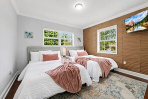 A hotel room with two beds, a large window with a view, a mounted TV, and a patterned rug. - Luxury 5BR Heated Pool, Game Room, Sandy Beach Area & Basketball (Miami)