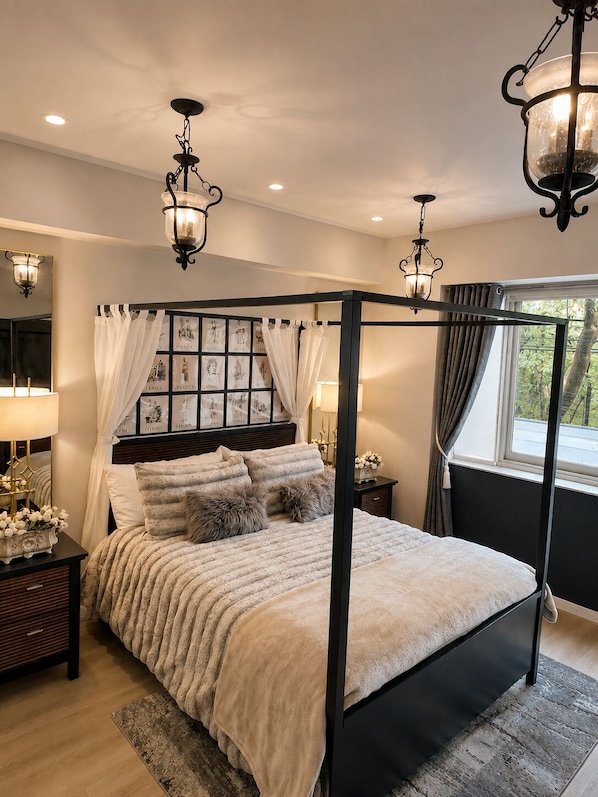 Una cama con dosel, mesitas de noche y apliques de pared.