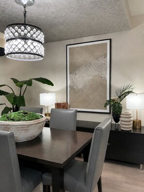 A dining area with a table, chairs, a potted plant, a wall art piece, and a pendant light. - CONDESA Two Bedroom, Pool, Gym Security 24/7 for group of 6. (Ciudad de México)
