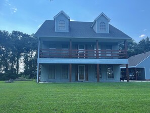 Een twee verdiepingen tellend huis met een balkon, een veranda en een garage.