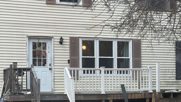 A house with a front porch, a door, and a window. - 2-bedroom condo in welcoming Plaistow close to beaches, mountains, and Boston (Plaistow)