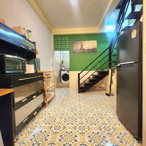 Eine Küche mit Mikrowelle, Backofen und einer grünen Wand mit Stadtbild.