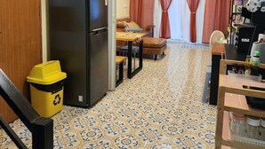 Eine Küche mit einem Kühlschrank, einem Esstisch und einem gemusterten Boden.