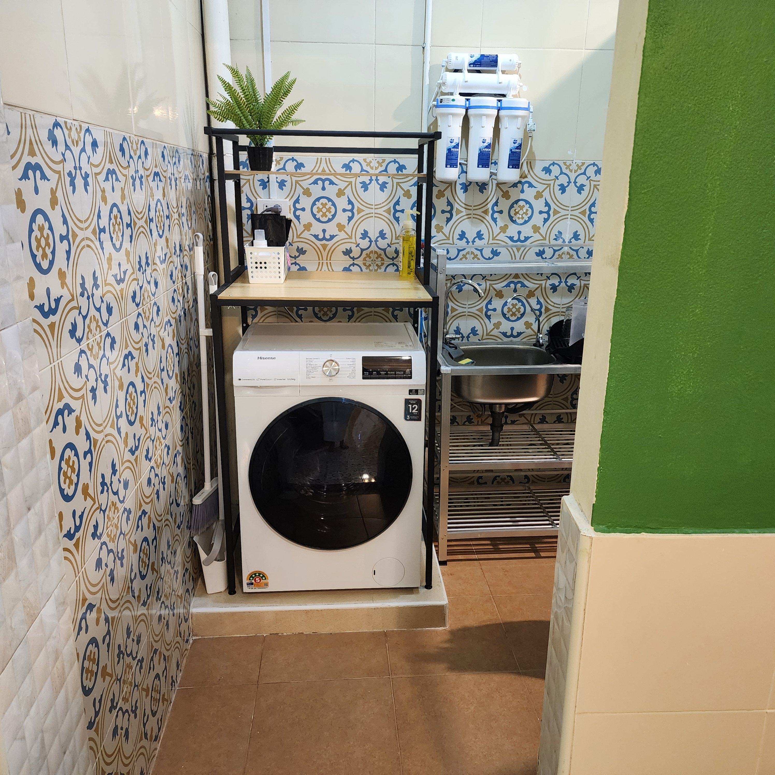 A compact laundry area with a washing machine, a sink, and a water filtration system.