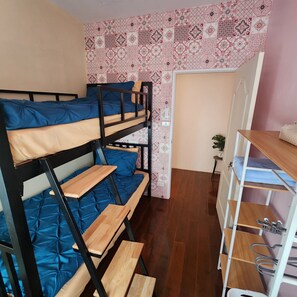 A bunk bed room with a patterned wall, a small plant, and a desk with shelves. - 3BR Local Bangkok Stay [10 Min Walk to BTS & Sathorn Pier ] • Easy City Access (Sathon)