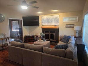 A living room with a fireplace, a flat-screen TV, and a sofa.