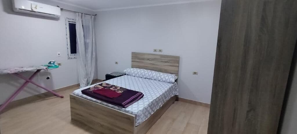 Un dormitorio con una cama, un escritorio y una silla.