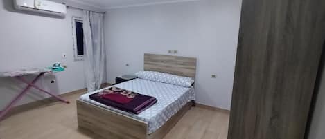 Un dormitorio con una cama, un escritorio y una silla.
