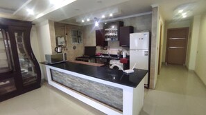 Una cocina moderna con una isla central, electrodomésticos integrados y un comedor.