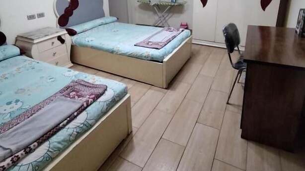 A bedroom with two beds, a desk, and a wardrobe. - Luxrious Comfy Apartments East Cairo (Cairo Governorate)