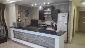 A modern kitchen with a central island, built-in appliances, and a backsplash. - Luxrious Comfy Apartments East Cairo (Cairo Governorate)