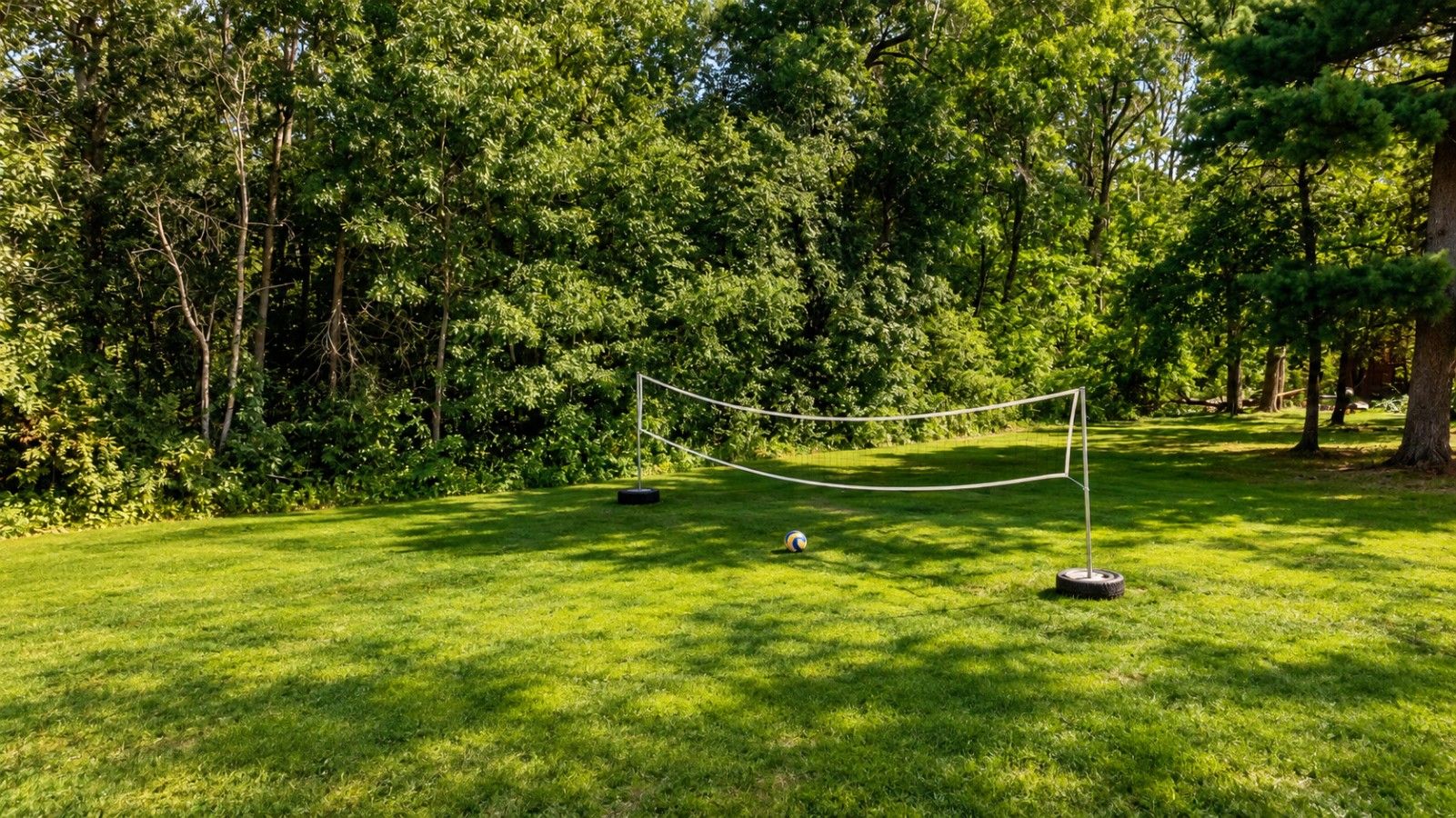 A grassy area with a rope barrier and a volleyball.