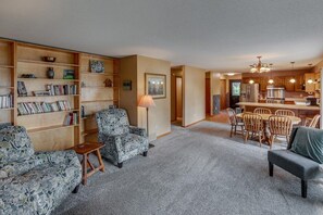 A living room with a fireplace, a dining area with wooden chairs, and a kitchen with modern appliances. - Blue Flag Shores Private Home (Pequot Lakes)
