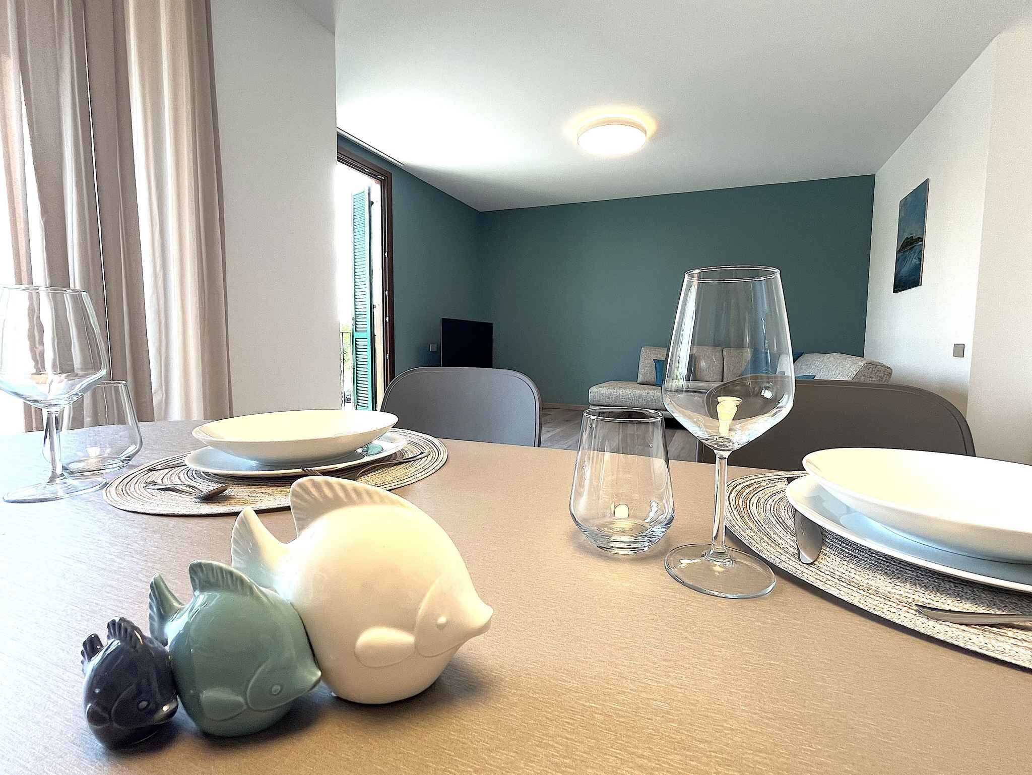 A dining table set with plates, glasses, and a decorative fish sculpture.