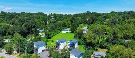 Un quartier résidentiel composé de plusieurs maisons, entouré d’une végétation luxuriante.