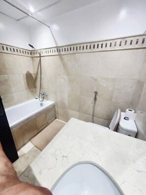 Een badkamer met een bad, een douche en een toilet.