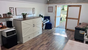 Una cocina compacta equipada con microondas, cafetera y un mueble con cajones.